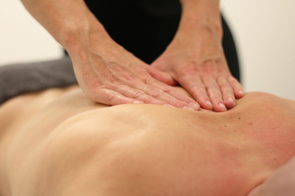 Gros plan sur des mains massant un dos